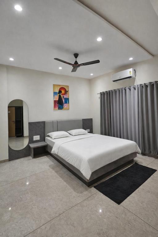 a bedroom with a bed and a ceiling fan at Hotel Abhishek Pride Shani Shinganapur in Godhegaon