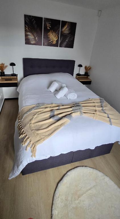 a bedroom with a bed with white sheets and blankets at Studio Albert 1er in Oye-Plage