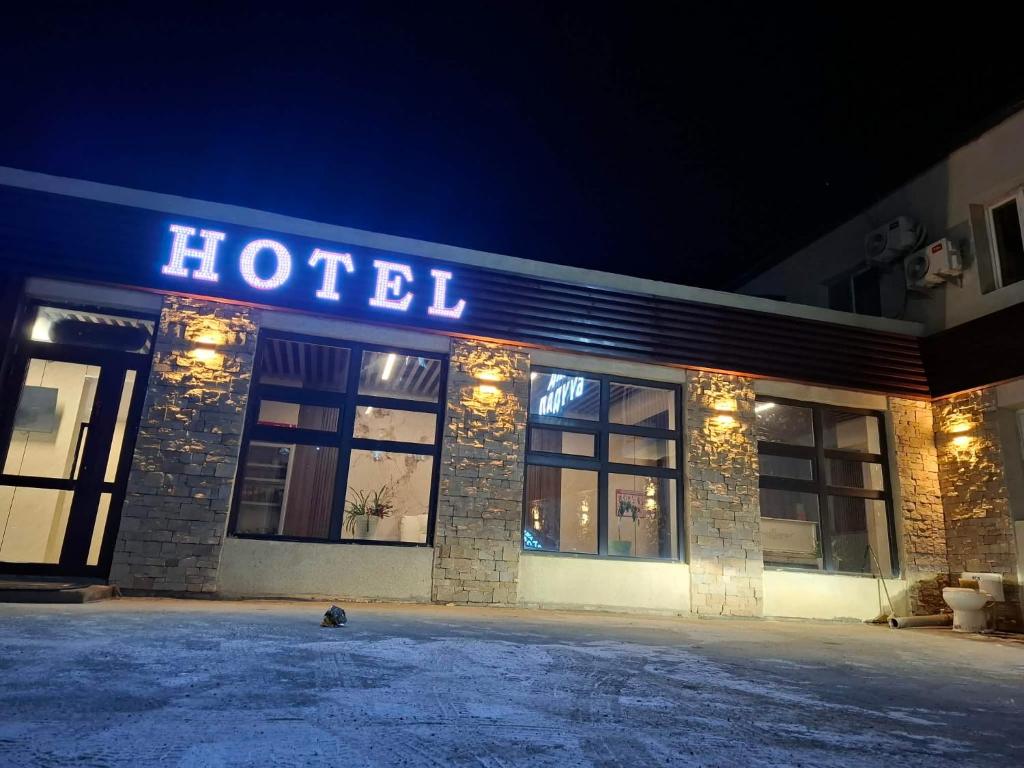 a hotel with a sign on the front of it at night at Khur motel in Dalandzadgad