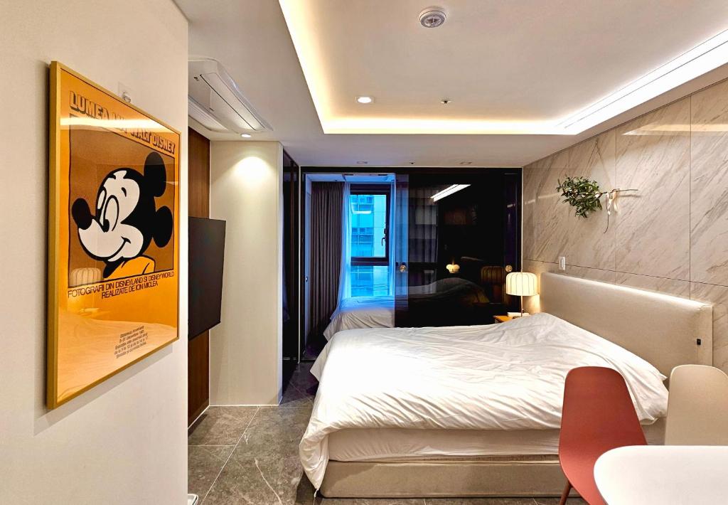 a bedroom with a mickey mouse poster on the wall at Cookie House in Seoul