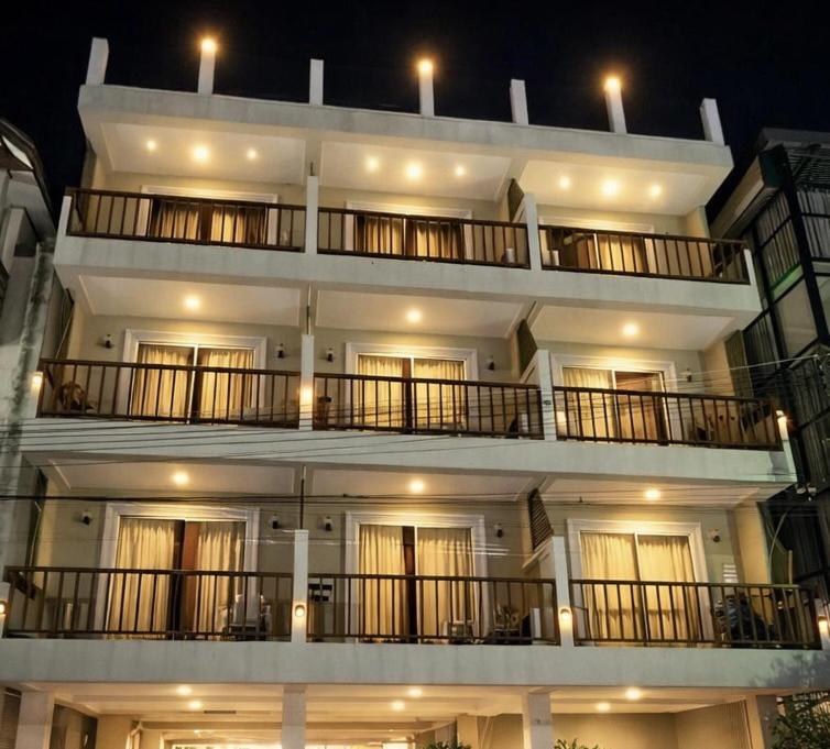 a large white building with balconies at night at Hi2 Cha-Am in Cha Am