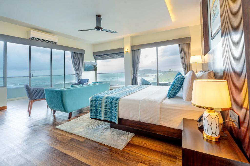a bedroom with a bed and a desk and windows at Sandy Bliss Mirissa in Mirissa