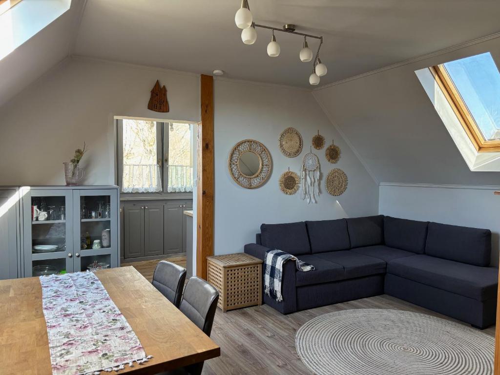 a living room with a blue couch and a table at Pioppo Apartman in Tiszavasvári