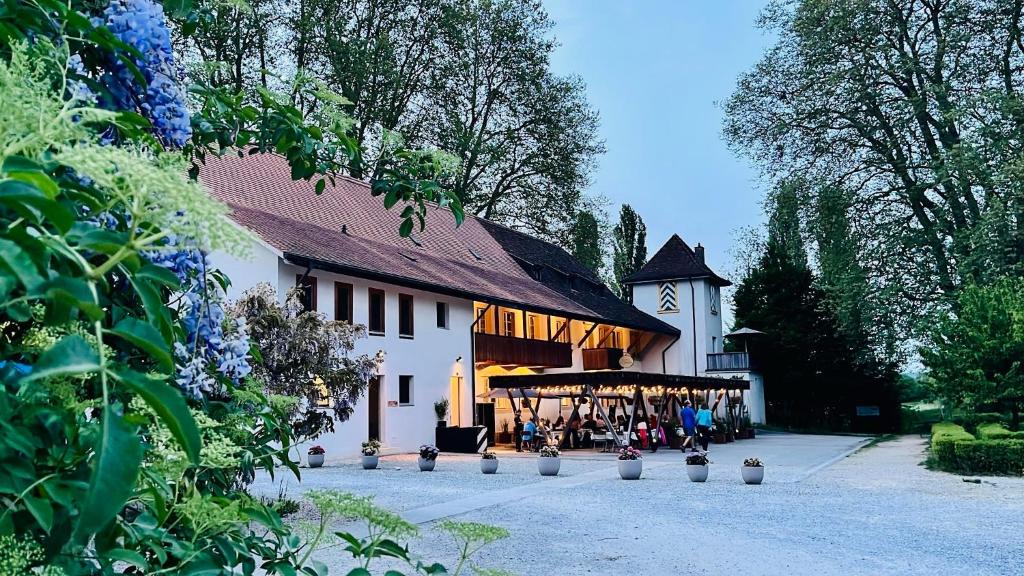 a large white building with a clock on the side of it at Hôtel Domaine de la Sauge in Cudrefin