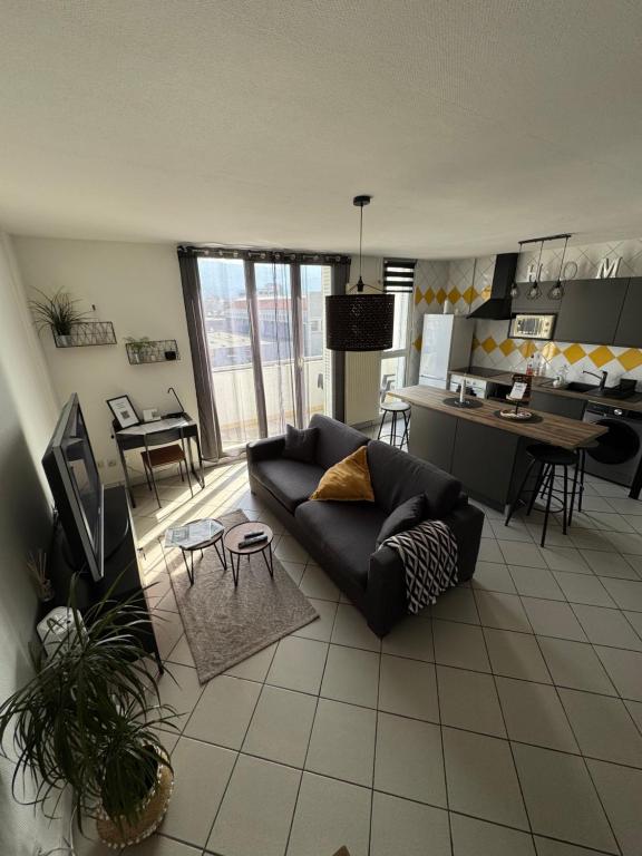 a living room with a couch and a kitchen at Le 305 Beauvert Parking Gratuit in Grenoble