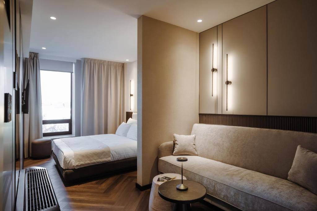a living room with a couch and a bed at Ferdinand Boutique in Cluj-Napoca