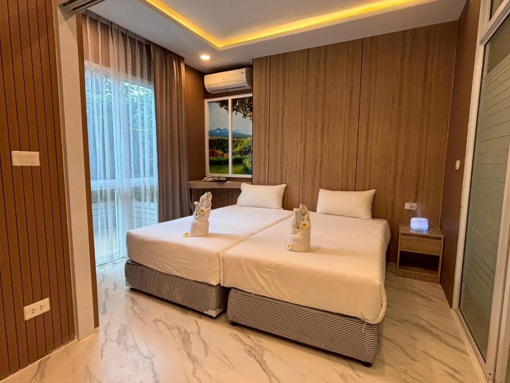a bedroom with a large white bed with a window at Deco Harmony Pattaya 1 in North Pattaya