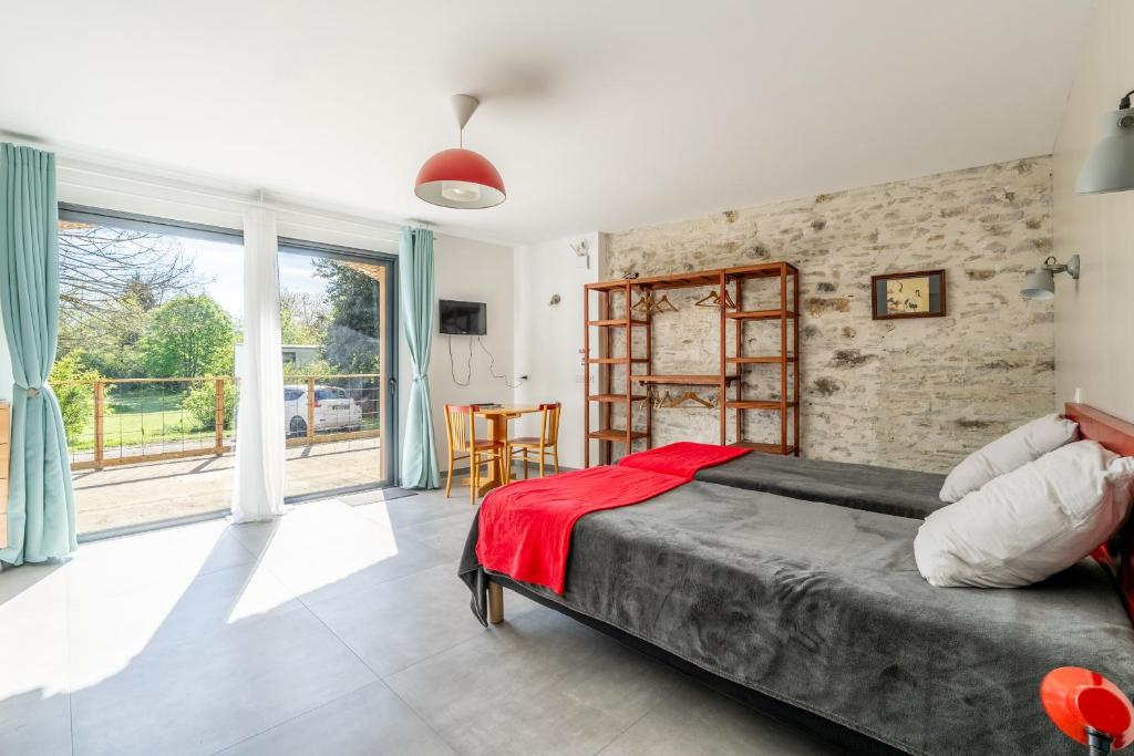 a bedroom with a bed and a brick wall at Studio L'Erdre au moulin - terrasse in Joué-sur-Erdre