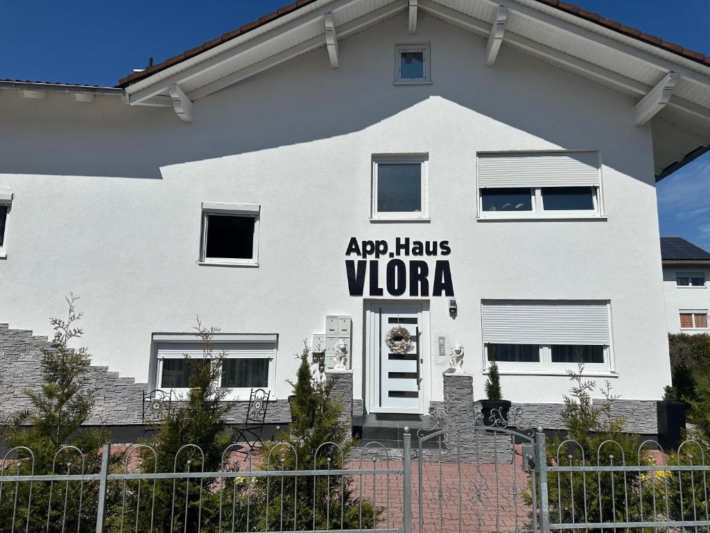 a white house with a sign that says apoc has vona at Appartementshaus Vlora 1 Einheit 2 in Bad Füssing