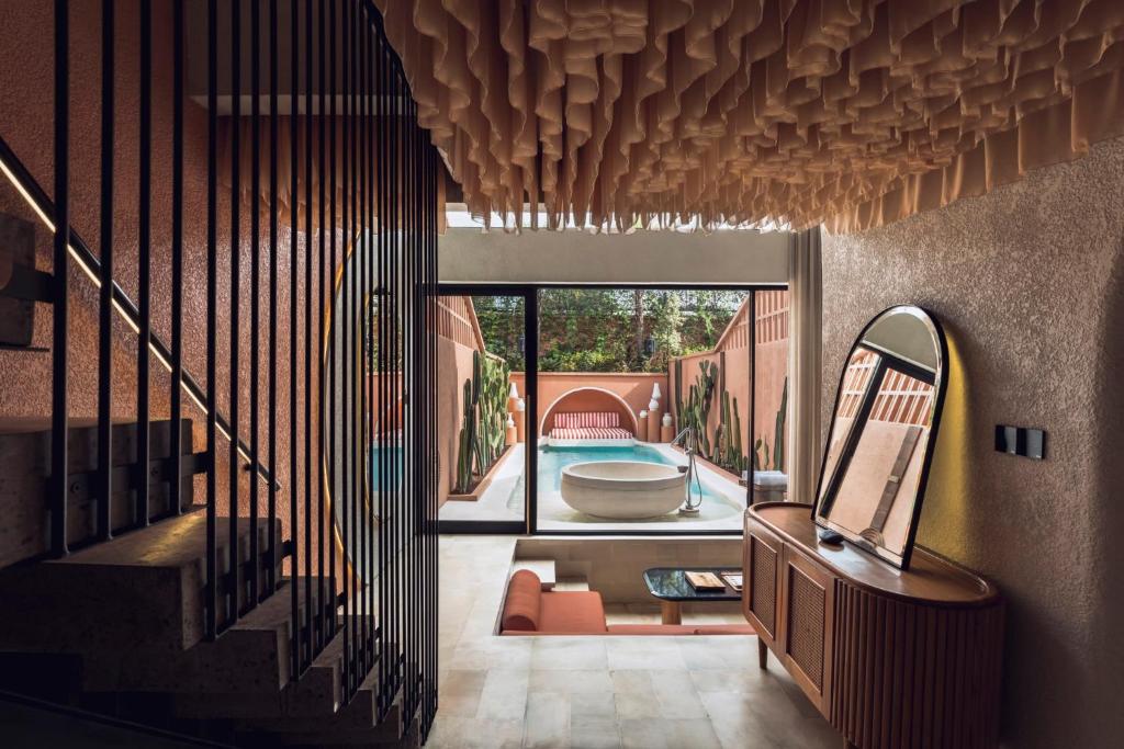 a room with a staircase and a mirror and a tub at Cyrus Villa Seminyak by Ini Vie Hospitality in Seminyak