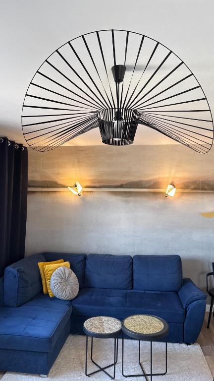 a living room with a blue couch and two tables at Apartament - U Alicji in Konin