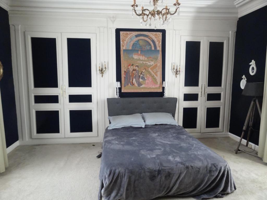 a bedroom with a bed and a painting on the wall at Maison centre-ville et proche du Circuit des 24H in Le Mans