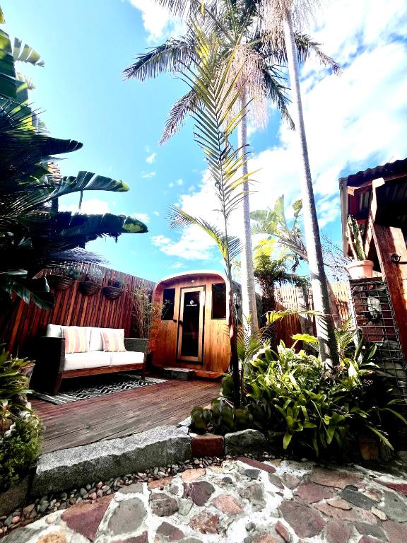 a living room with a couch and palm trees at Tathra Tides - Private Sauna - Walk to Beach and Cafés in Tathra