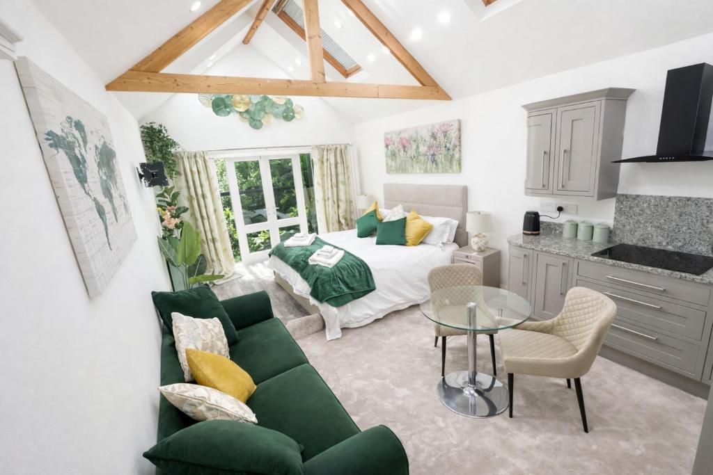 a living room with a green couch and a bed at The Garden Hideaway Central Corbridge in Corbridge