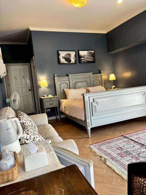 a bedroom with two beds and a couch at Maison Dang Boutique Hotel in Chiang Mai