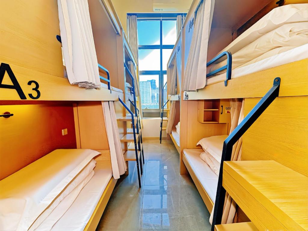 a row of bunk beds in a dorm room at 泊金青年旅舍-深圳北站店 in Shenzhen