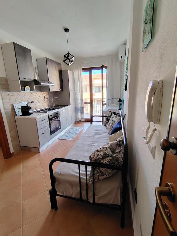 a living room with a couch and a kitchen at Casa Ventaglio Verde in Valledoria