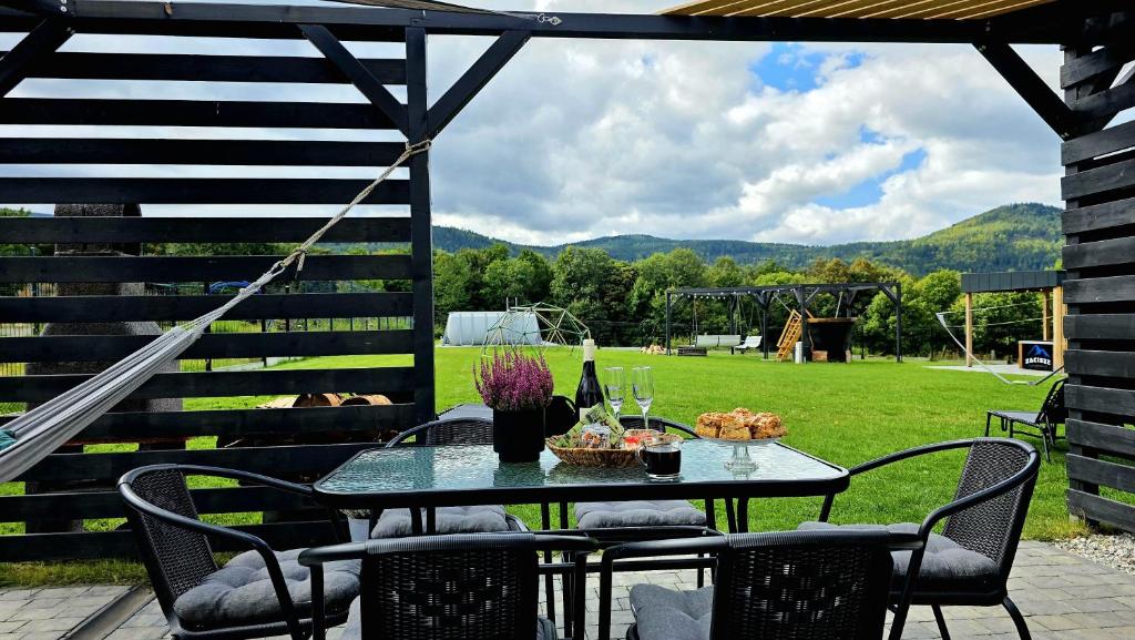 a table and chairs on a patio with a view of a field at Zacisze w Karkonoszach in Karpacz