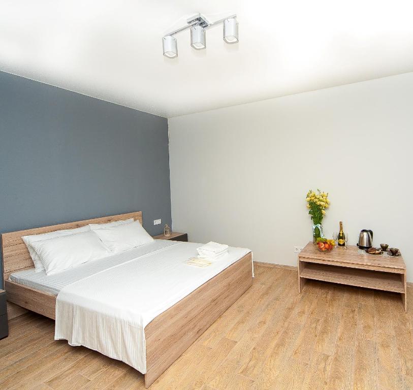 a bedroom with a white bed and a blue wall at Hotel Fusion in Odesa