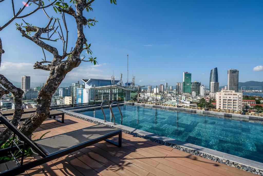 a swimming pool on top of a building with a city skyline at Tropical Dorm Hostel Da Nang by Haviland in Danang