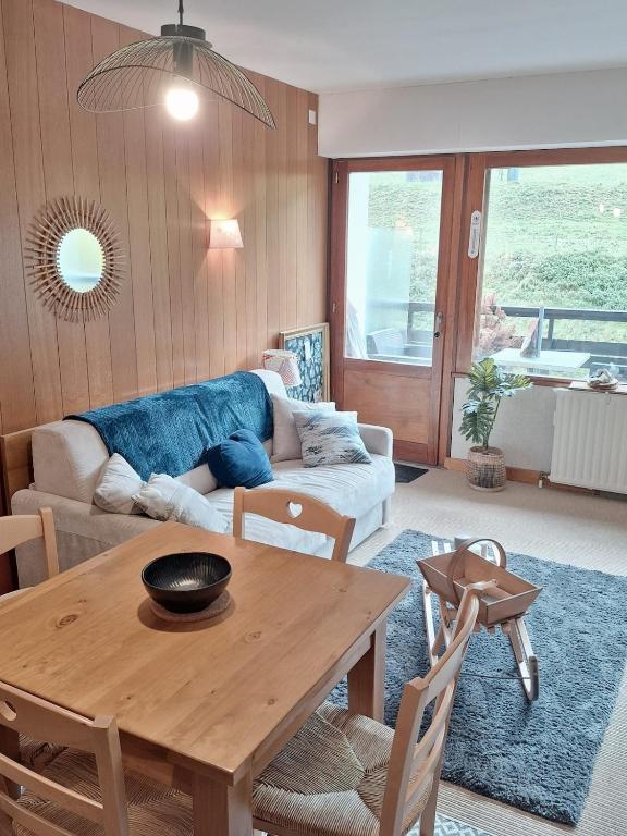 a living room with a table and a couch at Le Ptit Beau Jus in Aillon-le-Jeune