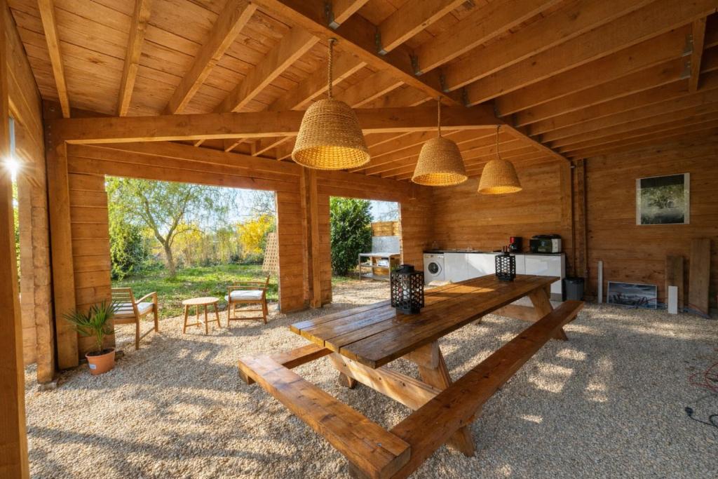 a wooden cabin with a table and a kitchen at Aux Gîtes d'Orient in Géraudot