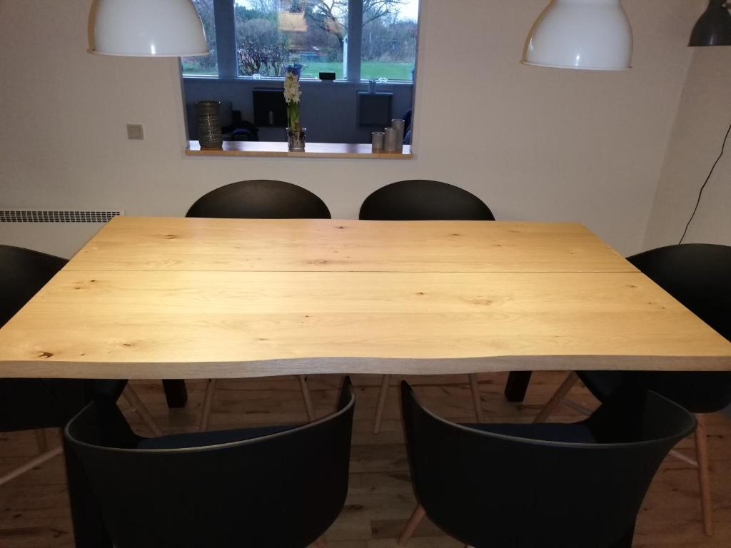 a wooden table with black chairs around it at Bogø feriehus in Bogø By