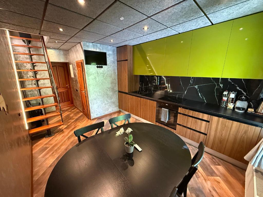 a kitchen with a large black table and chairs at BRIVIBAS RESIDENCE - WAVE, free PRIVATE parking, free WIFI, self check-in in Riga