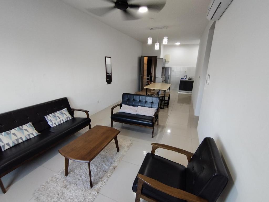 a living room with a couch and chairs and a table at Halimah Guesthouse in Putatan