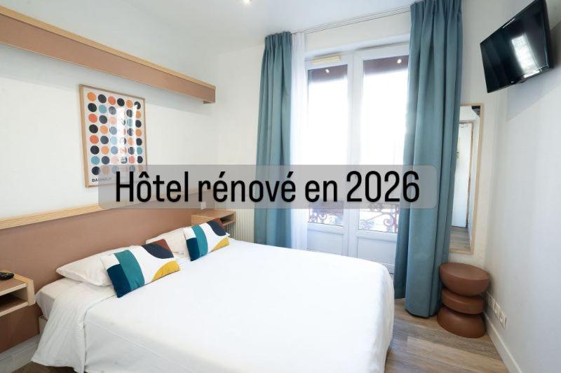 a hotel room with a bed and a window at Hôtel Edgar Quinet in Paris