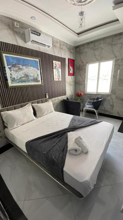 a bedroom with a large bed in a room at Jumeaux Studio in Luanda