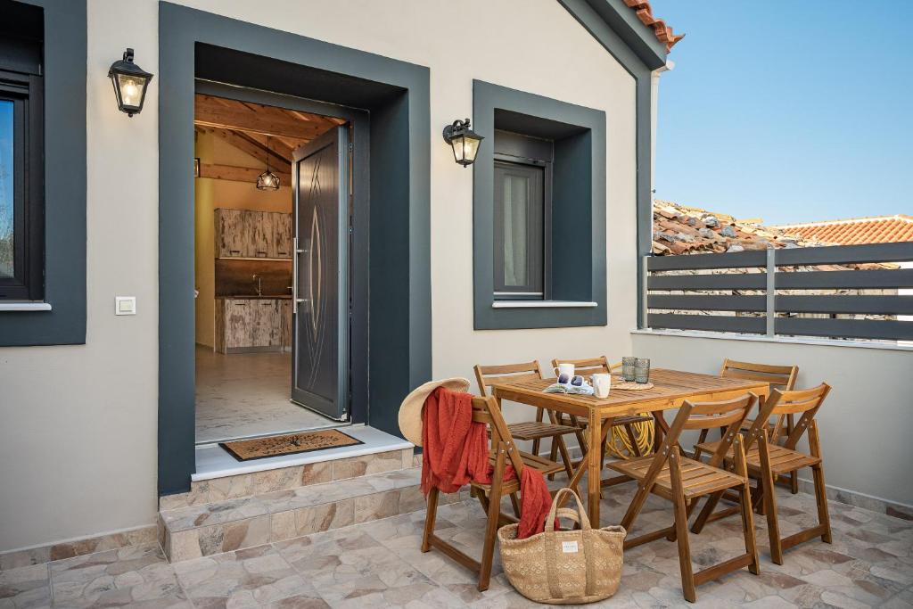 a patio with a wooden table and chairs at Sirius House in Mytilinioí