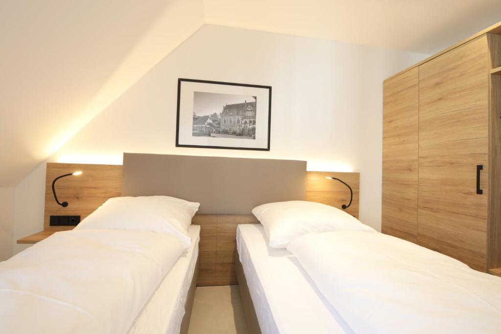 two beds in a room with white sheets at 3-2-1meins Schloss Burg bis 5 Pers DTV 4 Sterne Parkplatz WLAN Self Check-in in Remscheid