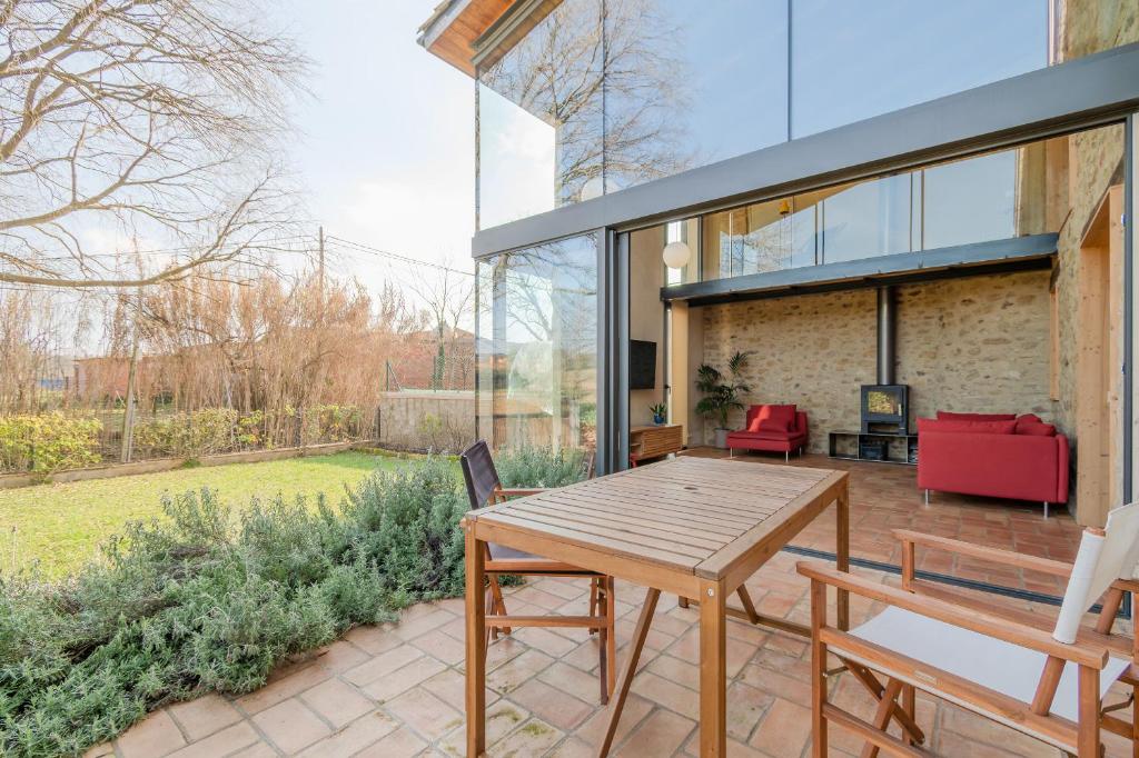 a patio with a wooden table and chairs at Flateli Cornellà del Terri in Santa Llogaia del Terri