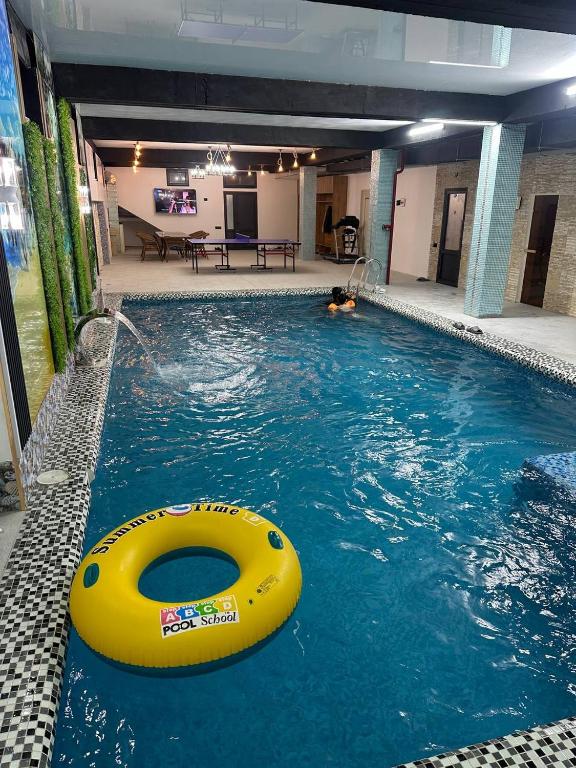 a swimming pool with a yellow raft in the water at MUXSIN s in Bukhara