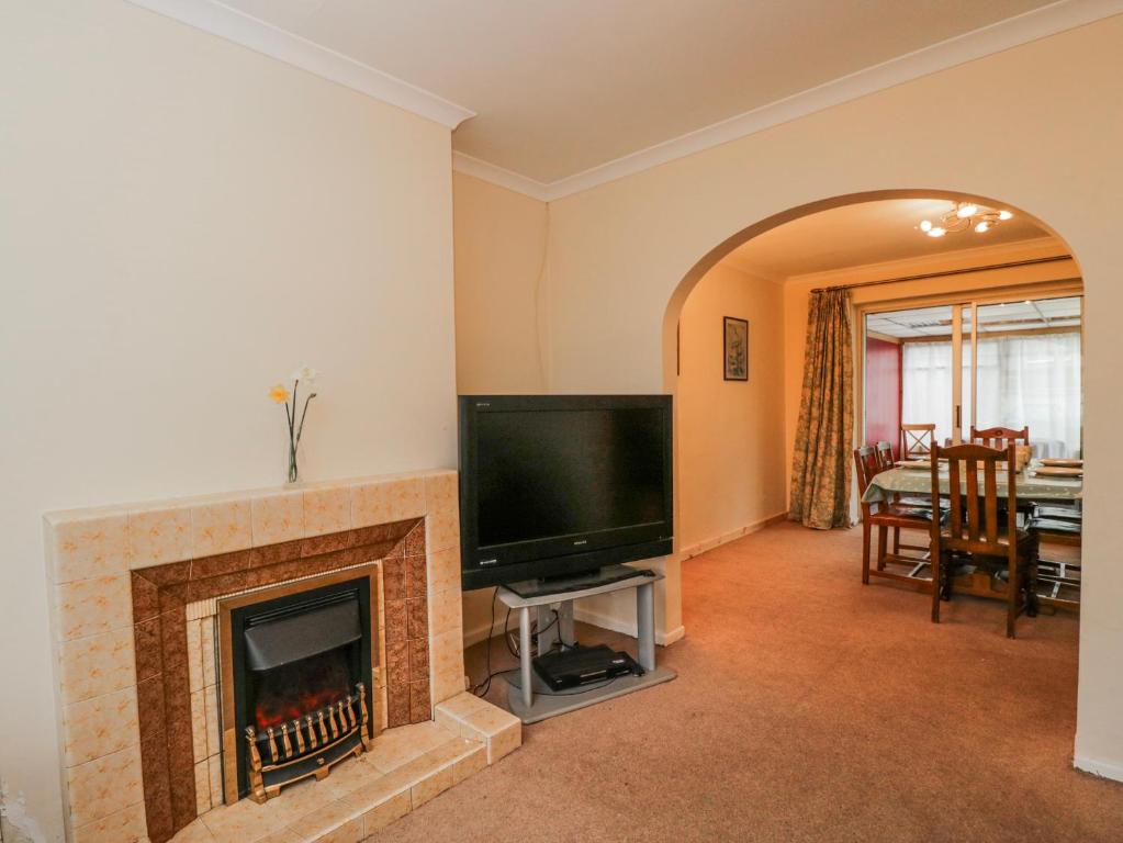 a living room with a tv and a fireplace at Lavender Harmony House in Swindon
