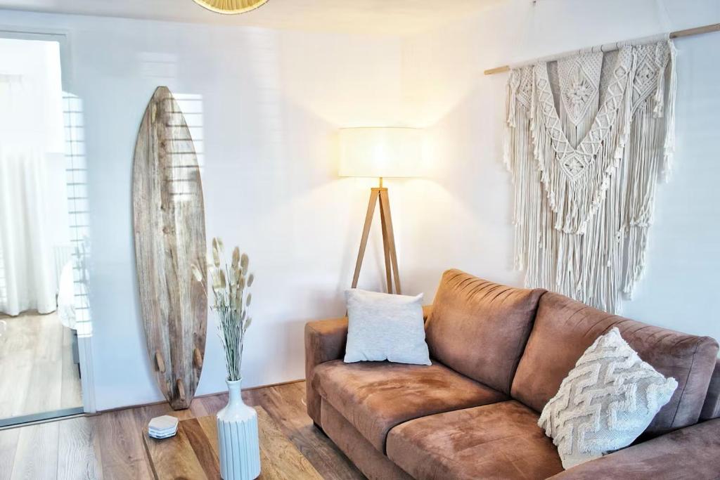 a living room with a brown couch and a lamp at Sotto Terra in Katwijk aan Zee