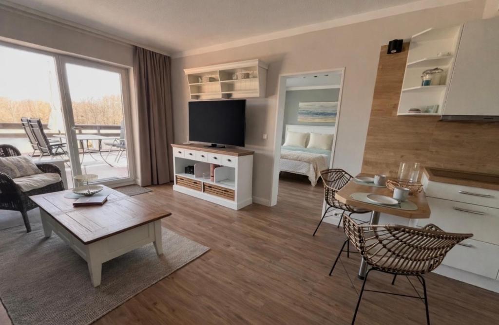 a living room with a couch and a table at Golfresidenz Landidyll B 107 in Grömitz