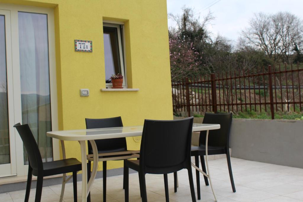 a table and chairs in front of a yellow wall at Il silenzio delle colline Umbre - Vicino Todi in Todi