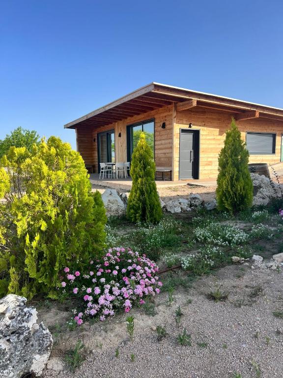 a log cabin with flowers in front of it at Casitas del MolinoGrande in San Miguel de Bernúy