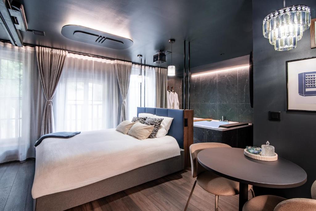 a bedroom with a bed and a table and a sink at La Suite Bleue in Cholet