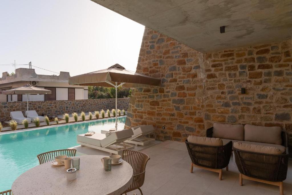 a patio with a table and chairs and a pool at Apartment Athina with direct pool access - GH8 in Gialova