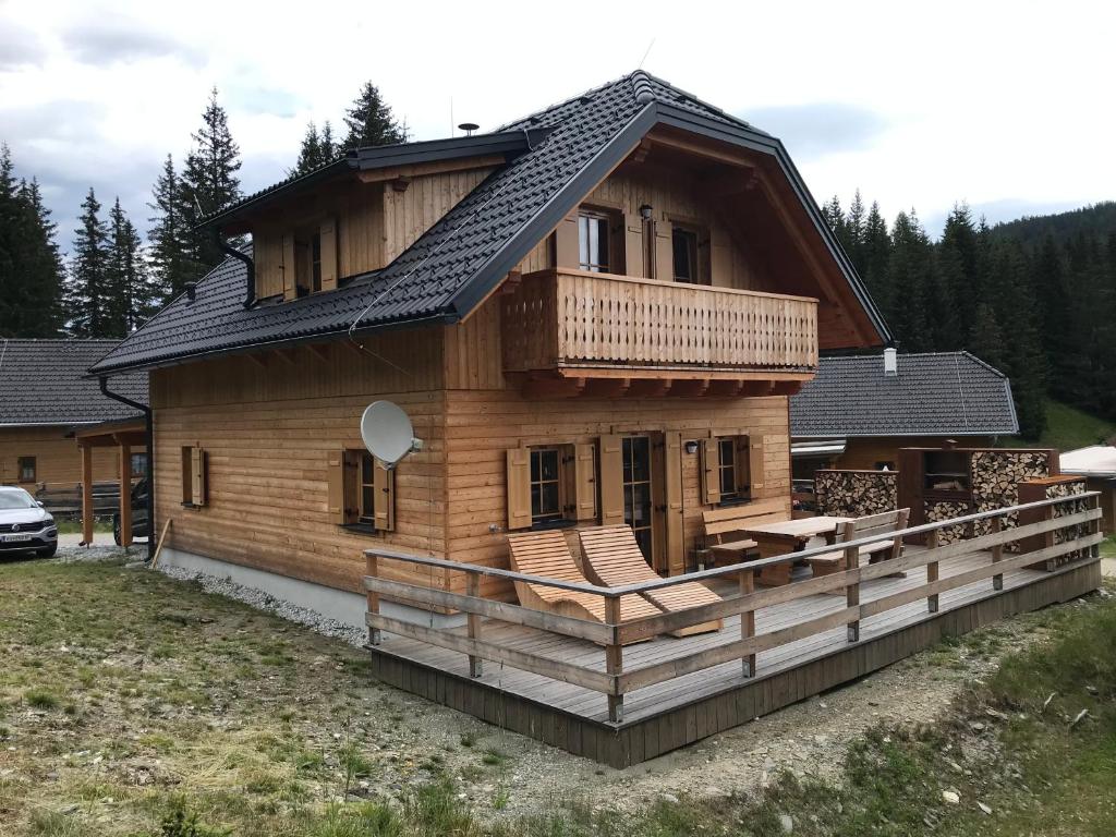 a large wooden house with a porch and a balcony at TANAs Almhütte in Flattnitz