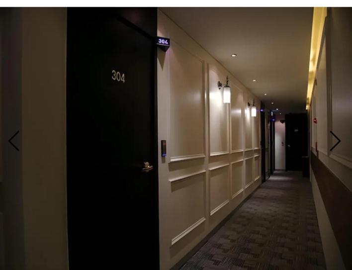 a hallway with a black door in a building at Motel Some in Suwon