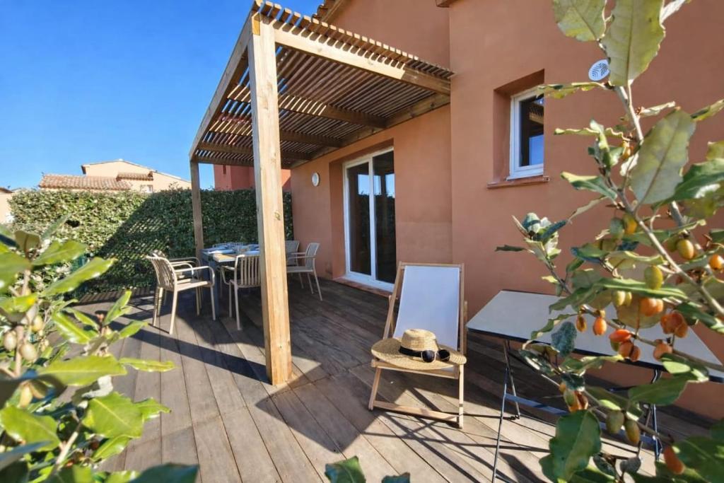 a patio with a table and chairs and a pergola at Valduccina - T3 avec terrasse et piscine, proche de la plage in Lecci