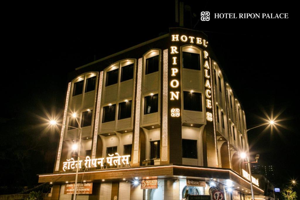 a hotel sign on the side of a building at night at Hotel Ripon Palace in Mumbai