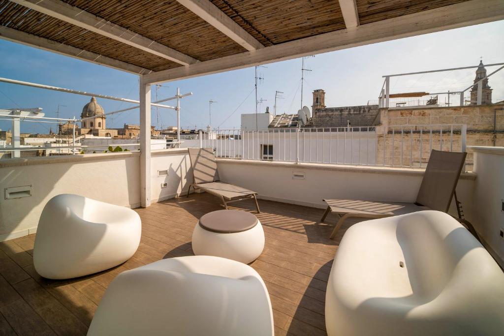 a balcony with white furniture on a roof at Le Contrade Vico Alba in Monopoli