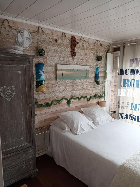 a bedroom with a bed and a mirror on the wall at LA MAISON DES HIPPOCAMPES in La Teste-de-Buch