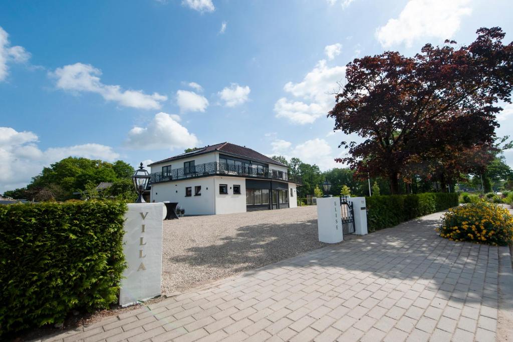 a large white house with a fence in front of it at Boutique Hotel Villa Elise in Winterswijk