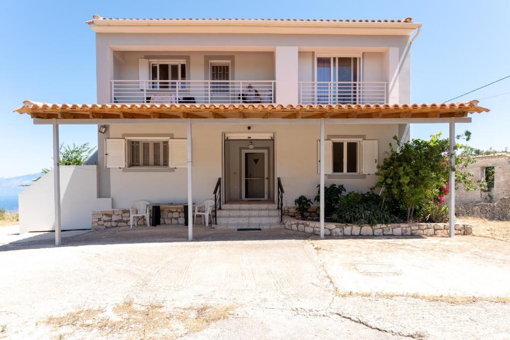 a white house with a porch and a balcony at Zante's Northern View in Koríthion